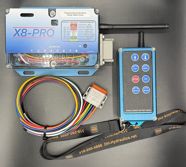 X8Pro wireless remote kit with anodized aluminum receiver box and blue aluminum transmitter, includes 8-wire color-coded harness with connector plug and DH-Hydraulics branded lanyard.