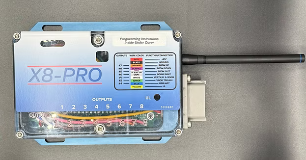 X8Pro wireless receiver in anodized aluminum case with antenna, showing output wiring label chart for 8 coil functions and numbered output terminals.